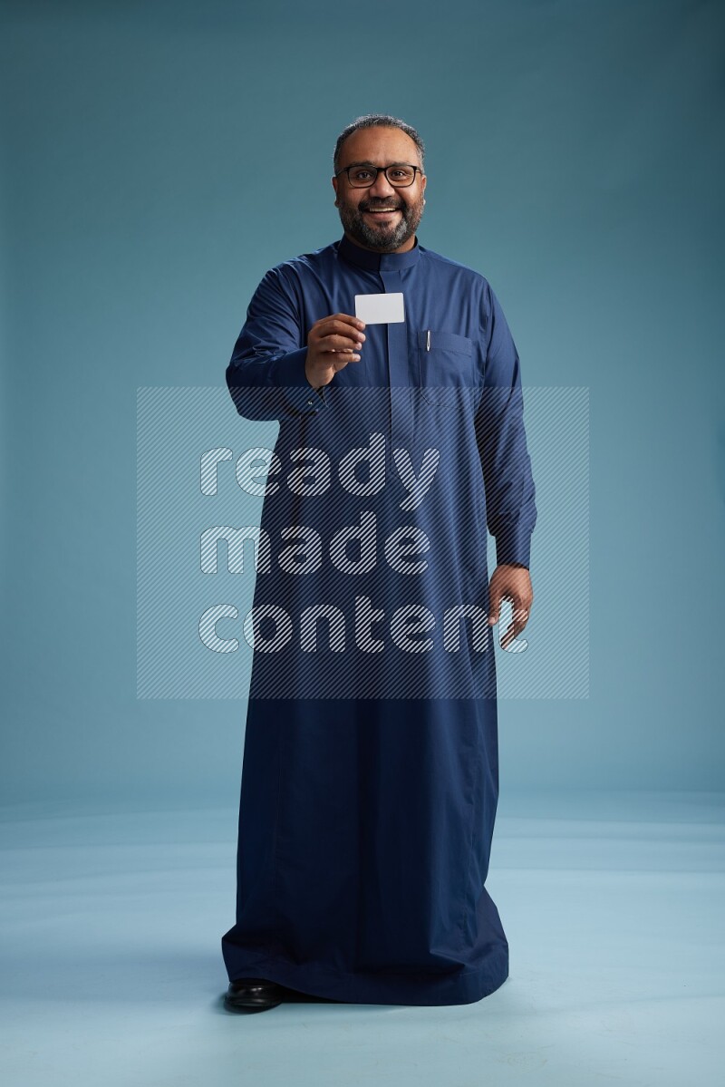 Saudi Man without shimag Standing holding ATM on blue background