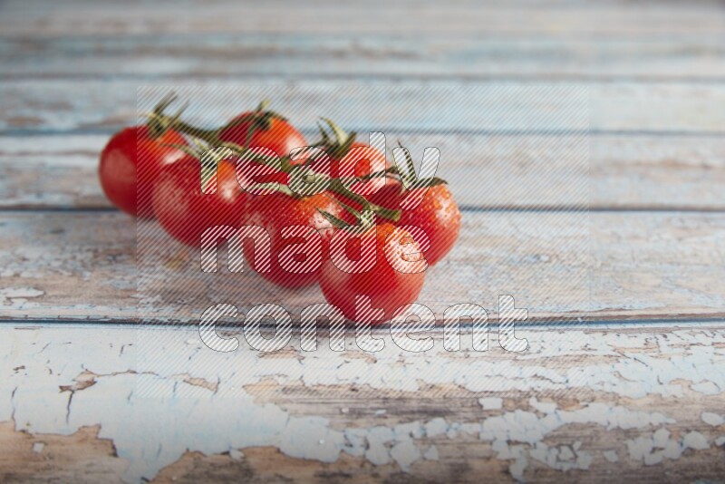Red cherry tomato vein on a textured blue wooden background 45 degree