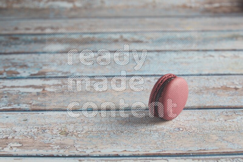 45º Shot of Red Cherry macaron on light blue wooden background