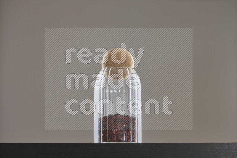 Sequins in a glass jar on black background