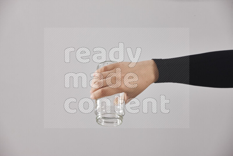 A woman in black abaya holding different glassware in different positions
