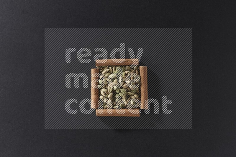 A single square of cinnamon sticks full of Cardamom on black flooring