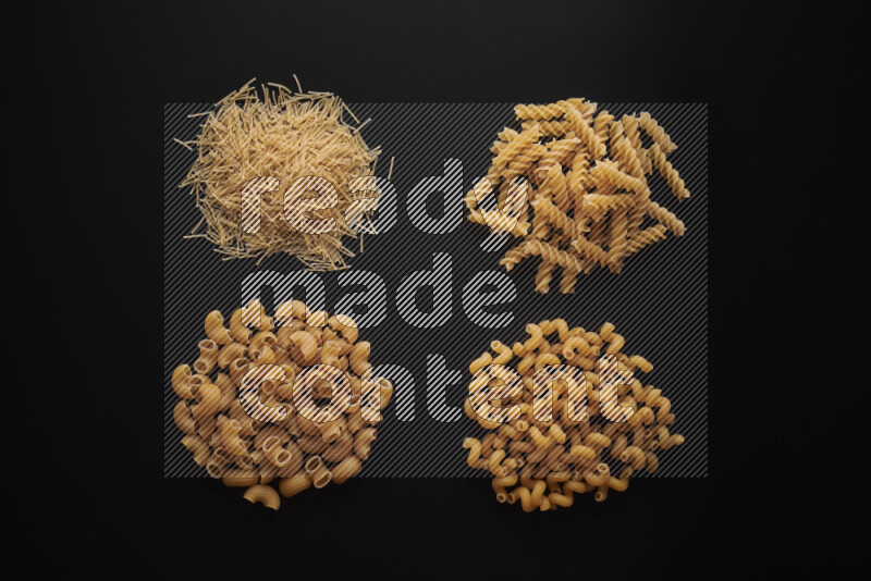 Different pasta types in bunches on black background