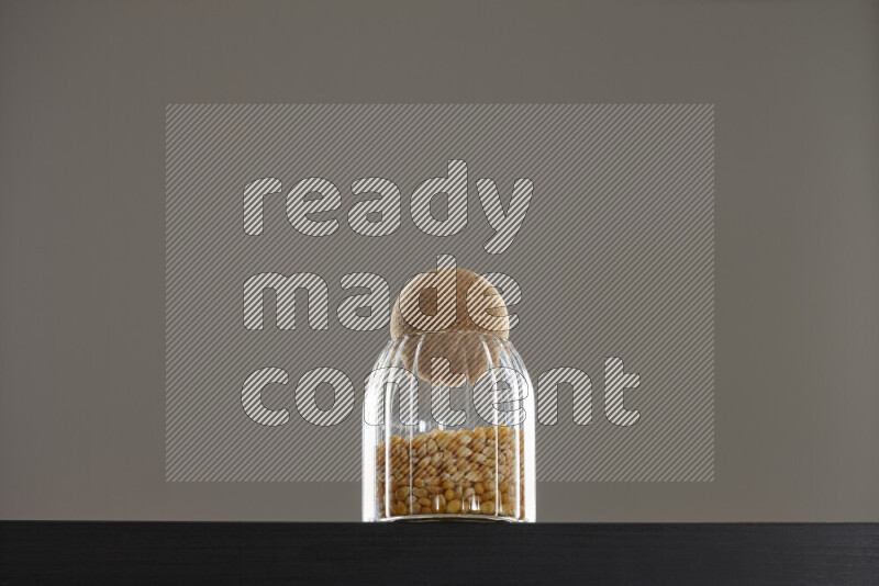 Pop corn in a glass jar on black background