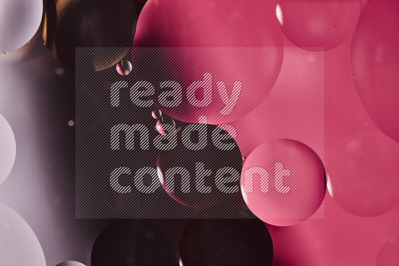 لقطات مقربة لفقاعات من الزيت على سطح الماء باللون الأسود والوردي