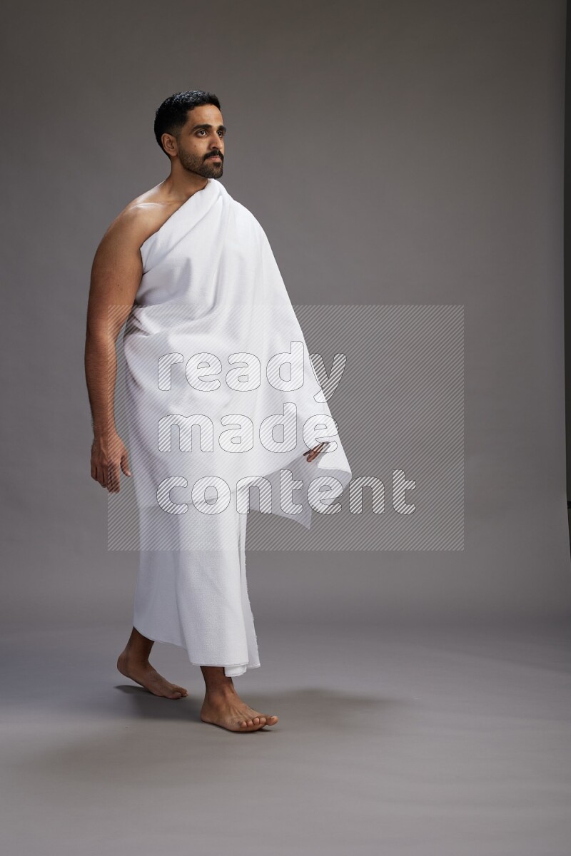 A man wearing Ehram Standing Interacting with the camera on gray background