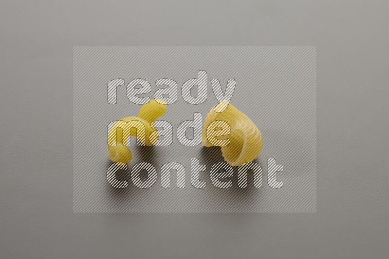 Twist pasta with other types of pasta on grey background