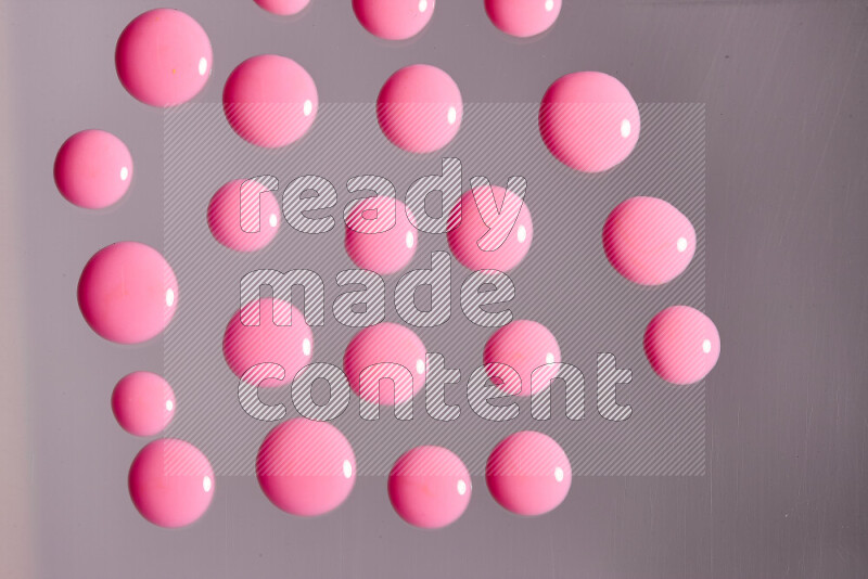 Close-ups of abstract pink paint droplets on the surface