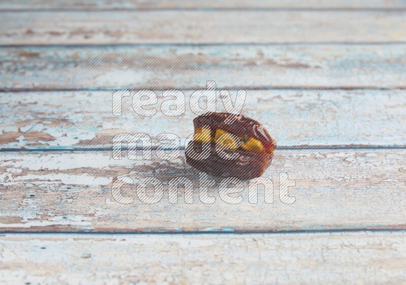 pistachio stuffed madjoul date on a light blue wooden background