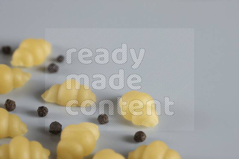 معكرونة مع مكونات متنوعة من الطماطم والثوم والبصل والفلفل الأحمر والفلفل الأسود والفلفل الأبيض وأوراق الغار وإكليل الجبل والهيل و مشروم على خلفية زرقاء فاتحة