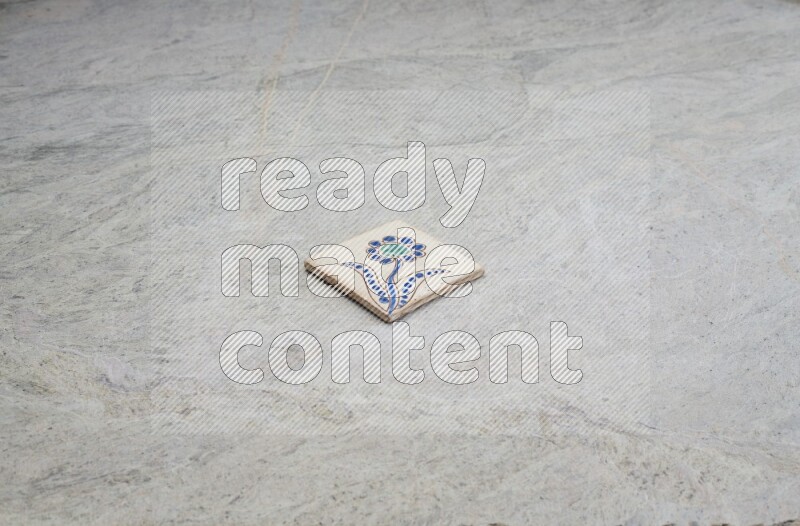 Top view shot of a pottery coaster\ tile on beige marble flooring