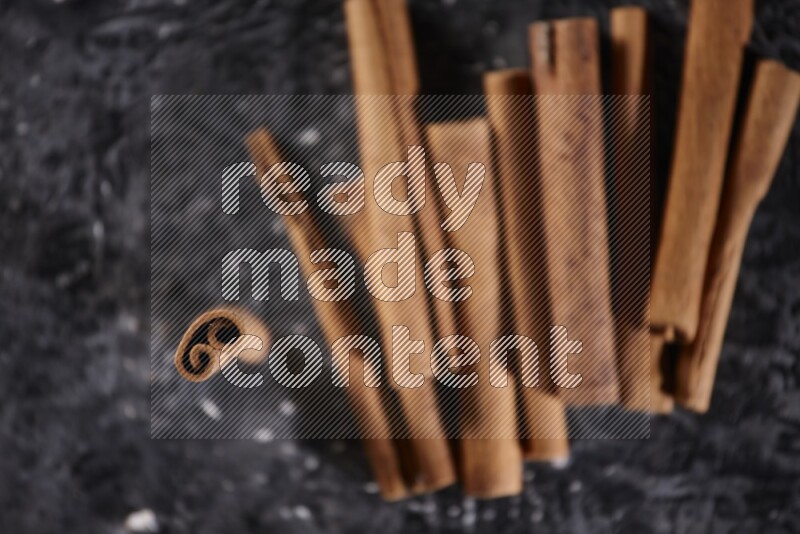 Cinnamon sticks on a textured black background