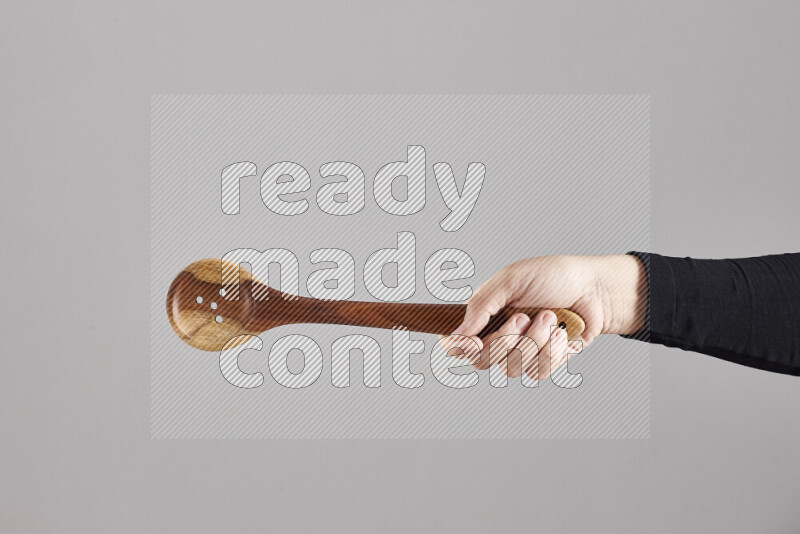 امرأة ترتدي عباءة سوداء تحمل أدوات خشبية مختلفة في أوضاع متعددة