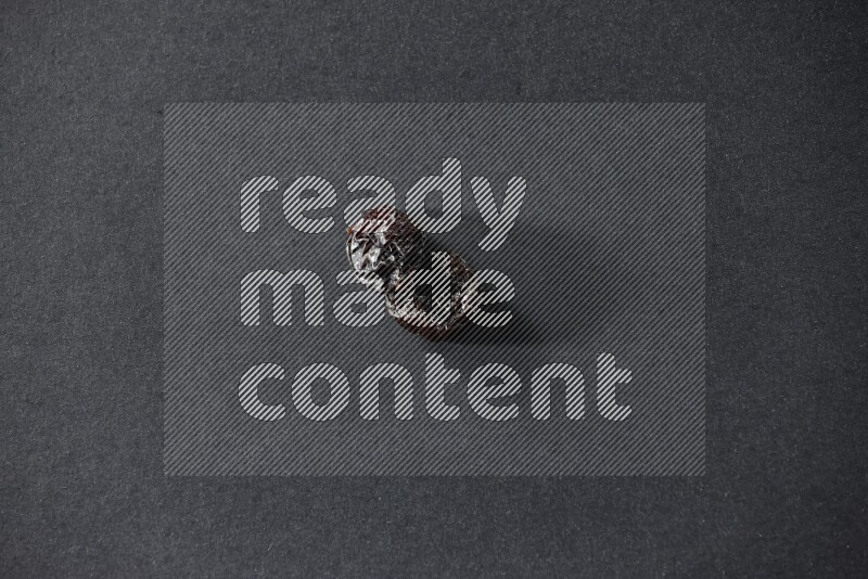 حبتان من البرقوق المجفف على خلفية سوداء