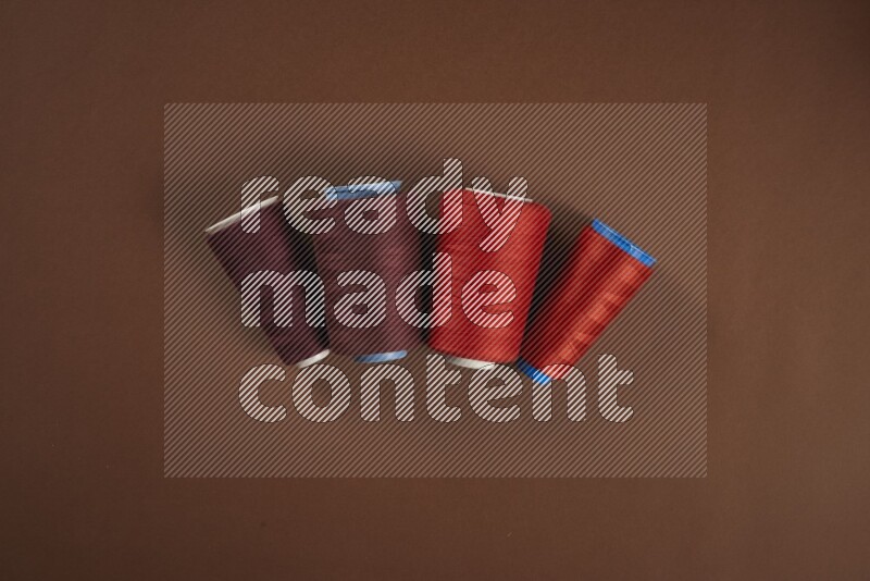 مجموعة من أدوات الخياطة والتفصيل حمراء اللون على خلفية بنية