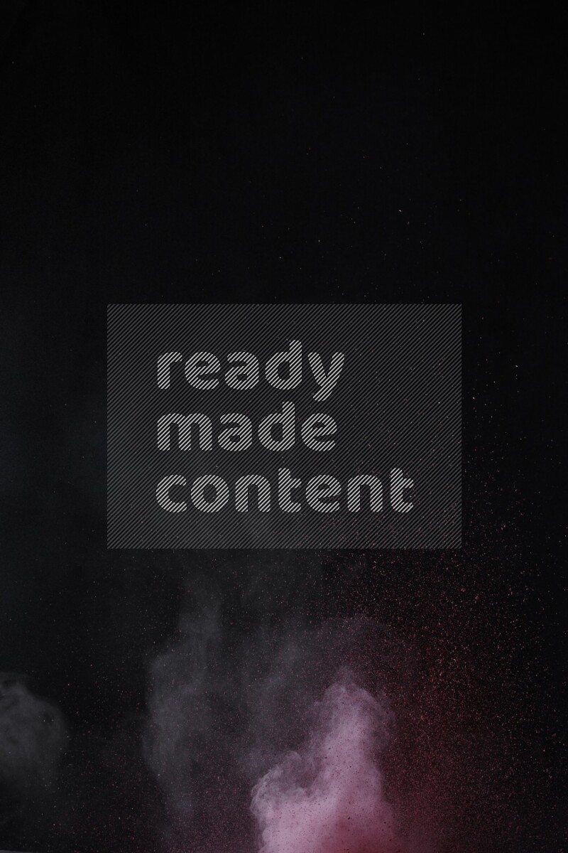 A side view of red powder explosion on black background