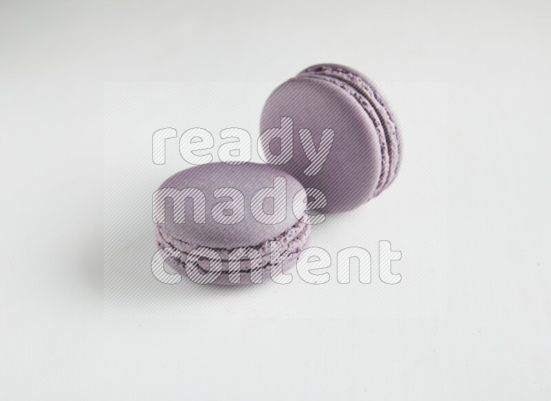 45º Shot of two Purple Blueberry macarons on white background