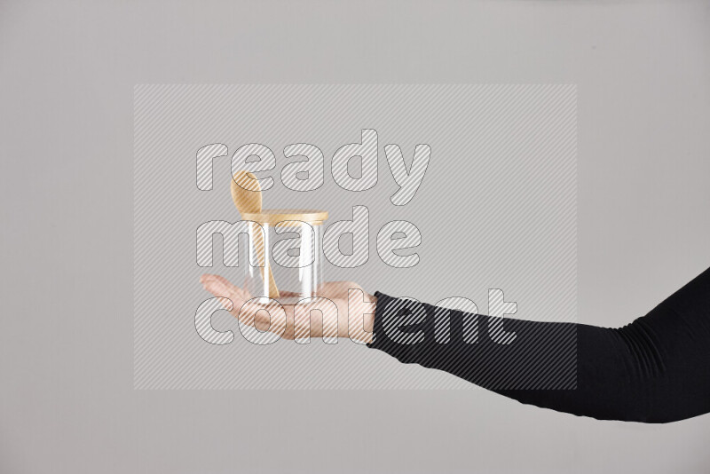 A woman in black abaya holding different glassware in different positions