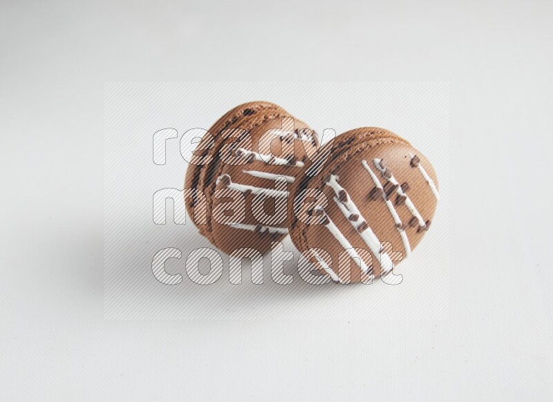 45º Shot of two Brown white Chocolate Caramel macarons on white background