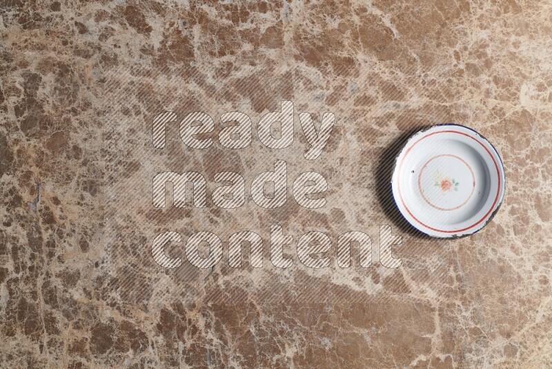 A vintage metal plate on beige marble background