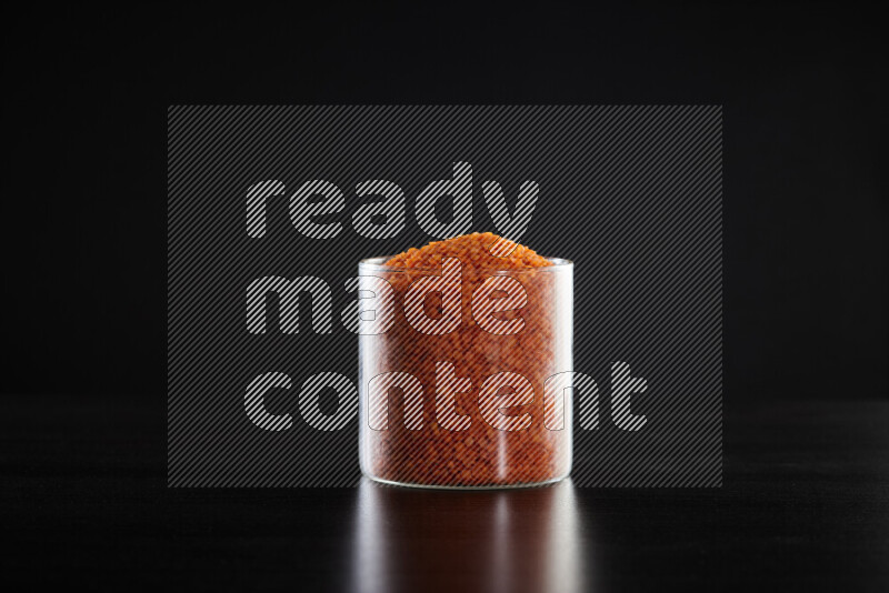 Lentils in a glass jar on black background
