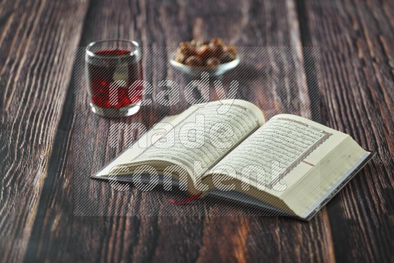 Quran with dates, prayer beads and different drinks all placed on wooden background