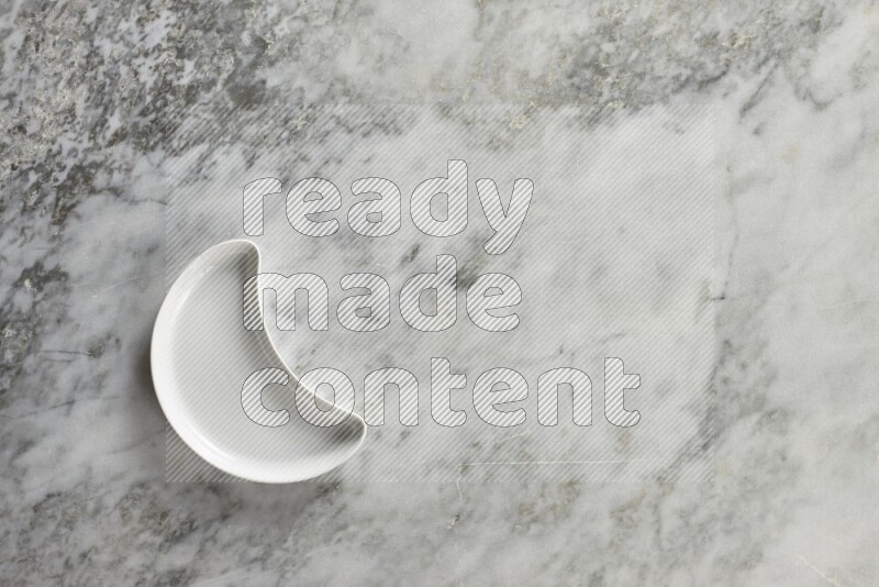 A pottery crescent plate on grey marble background