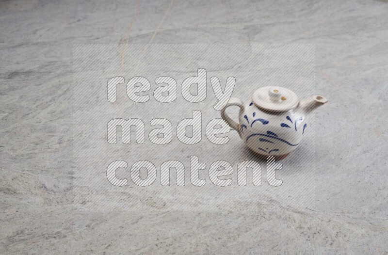 A pottery teapot on grey marble background