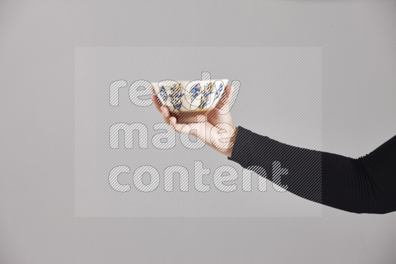 A woman in black abaya holding different pottery essentials in different positions