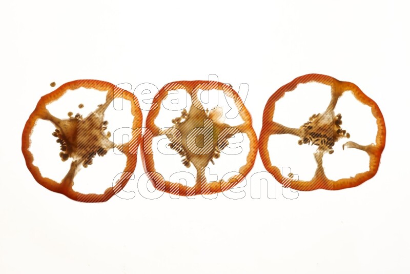Red bell pepper slices on illuminated white background