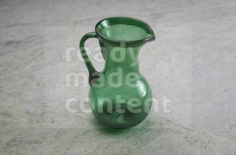 A colored glass jug on grey marble background