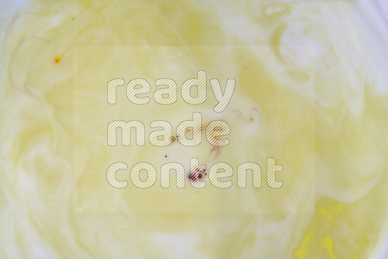 A close-up of abstract swirling patterns in yellow and white