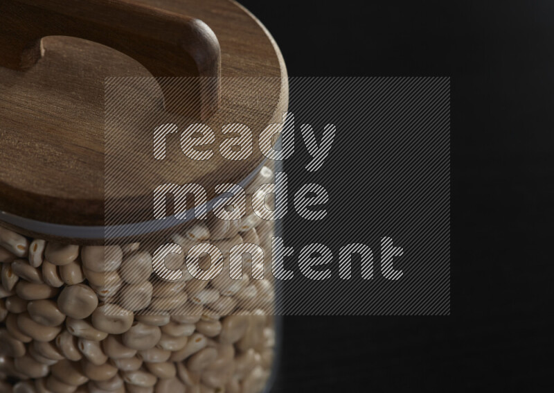 Lupin Beans in a glass jar on black background