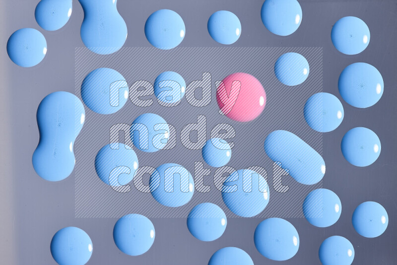 Close-ups of abstract pink and blue paint droplets on the surface