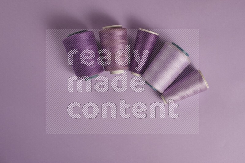 A purple collection of sewing and tailoring tools arranged on a purple background