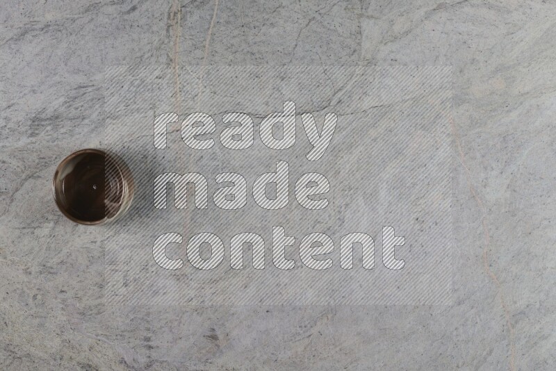 A multicolored pottery Cup on grey marble background