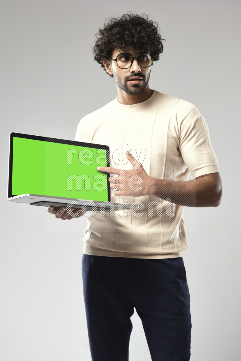 A man wearing casual standing and showing a laptop screen on white background