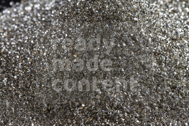 Silver shimmering fragments of glass scattered on a black background