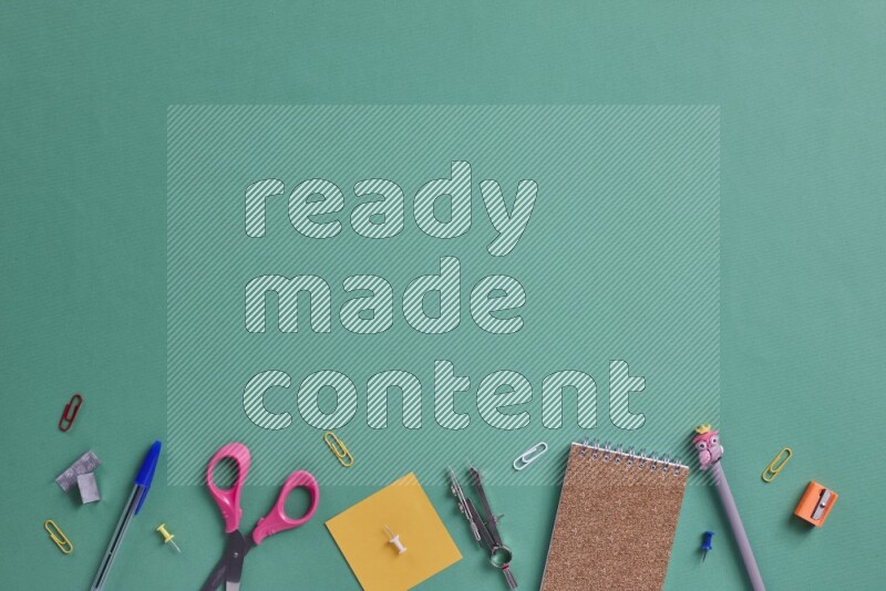 Different school supplies on green background