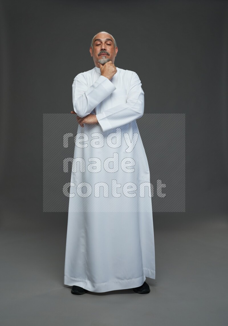 Saudi man without shomag Standing Interacting with the camera on gray background