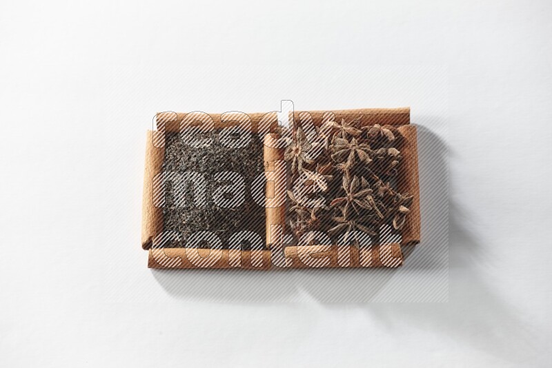 2 squares of cinnamon sticks full of star anise and black tea on white flooring