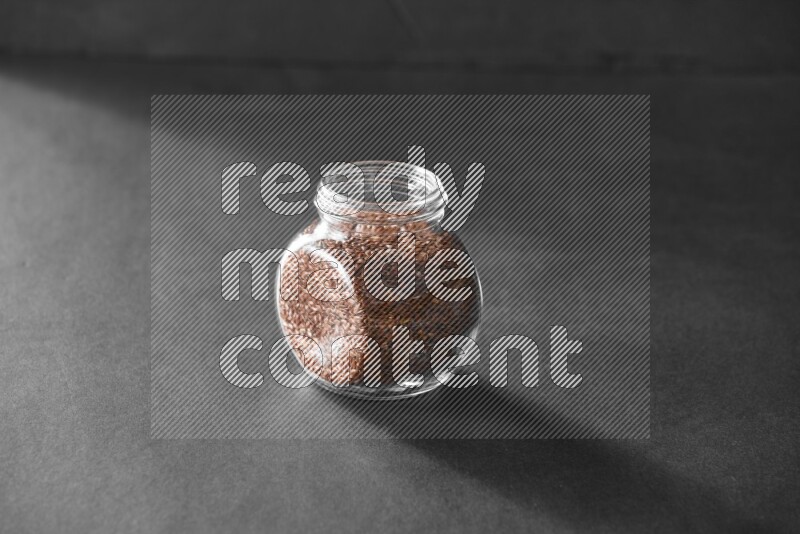 حبوب الكتان في وعاء زجاجي علي خلفية سوداء