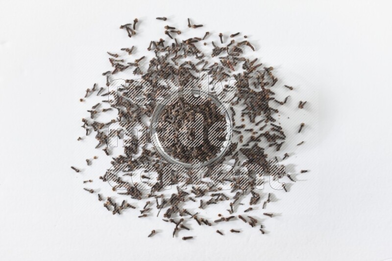 A glass bowl full of cloves on a white flooring