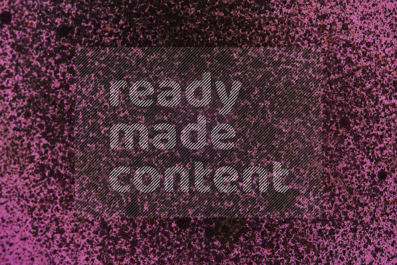 لقطات مقربة لقطرات ألوان مائية سوداء على سطح الزيت على خلفية وردية