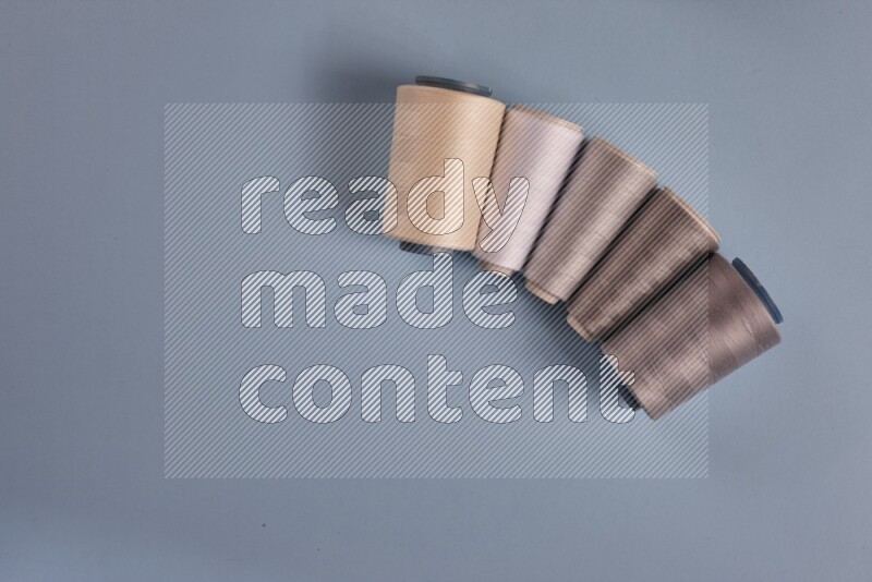 A grey collection of sewing and tailoring tools arranged on a blue background