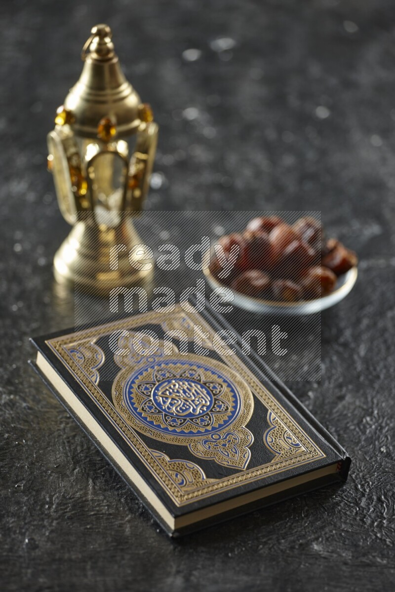 A golden lantern with different drinks, dates, nuts, prayer beads and quran on textured black background