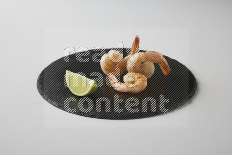 three grilled shrimp  on a black slate direct  on a white back ground