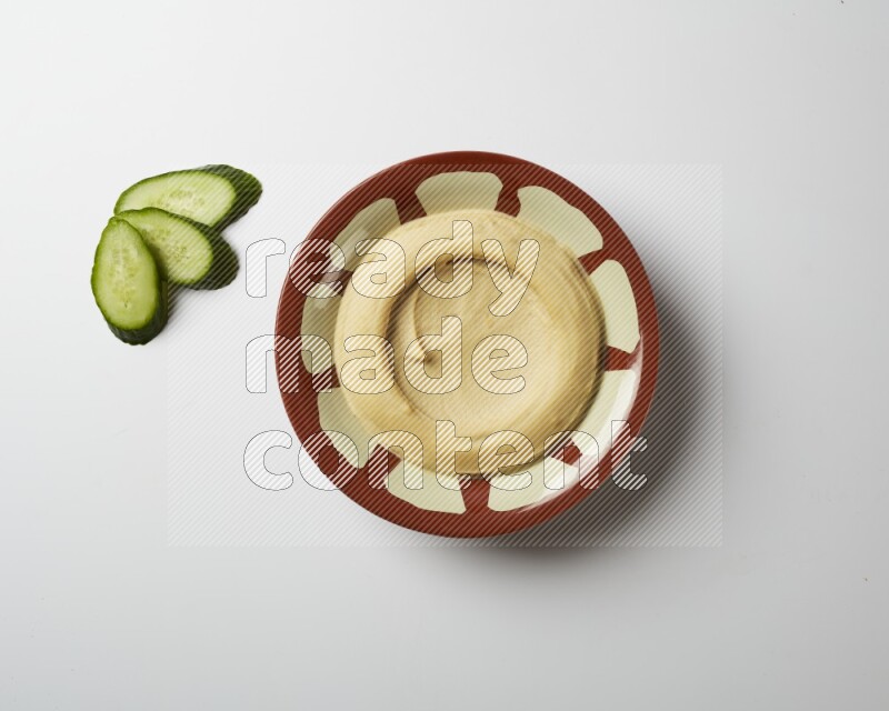 Plain hummus in a traditional plate on a white background