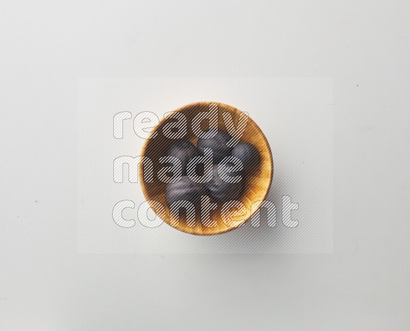 Top-view shot of dried lime (loomi) in a container on white background
