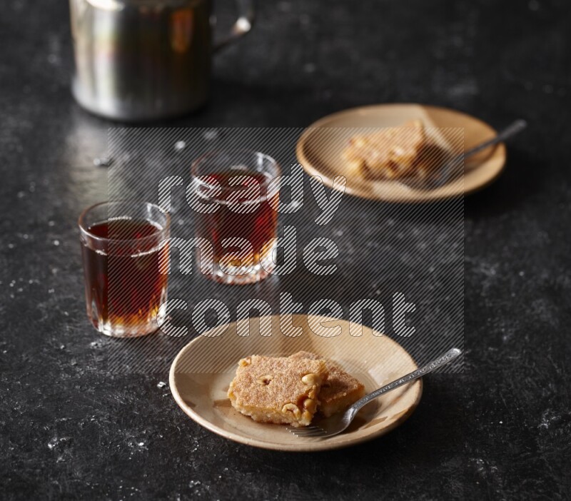 Basbousa with tea in a dark setup